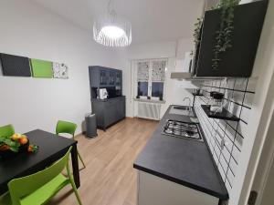 a kitchen with black counter tops and green chairs at aria di mare in Sestri Levante