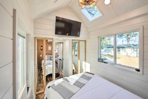 Un dormitorio con una cama y un televisor de pantalla plana. en Shared Dock and Lake Access Daingerfield Tiny Home, en Daingerfield