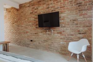 a brick wall with a white chair and a tv on it at Villas Colón 18 in Coatepec