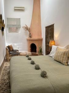 a bedroom with a large bed with a fireplace at Riad Sierra in Marrakesh