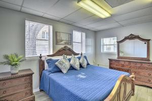 a bedroom with a blue bed with a dresser and a mirror at Serene Daytona Beach House with Private Yard! in Daytona Beach