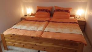 a bed in a room with two lamps on two tables at Haus Sonja in Adenau