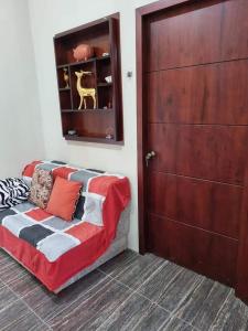 Habitación con cama con puerta y armario en La Casa de Amelia, en Puerto Baquerizo Moreno
