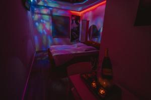 a room with two beds in a room with red and blue lights at Motel Príncipe Encantado in Mealhada