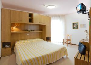 1 dormitorio con 1 cama y TV en Hotel Bianchi en Bibione
