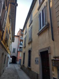 an alley with two buildings and a door at Suite Apartment San Lazzaro in Bergamo +7 photos