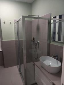 a bathroom with a sink and a glass shower at Suite Apartment San Lazzaro in Bergamo