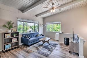 ein Wohnzimmer mit einem blauen Sofa und einem Fernseher in der Unterkunft Sunny Pahoa Retreat Snorkel, Hike and Shop! in Pahoa