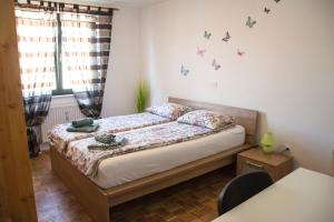 a bedroom with a bed with butterflies on the wall at Apartment San Izola - near the beach in Izola