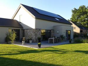 una casa con un tetto solare su un prato di B&B Maison Pierreuse a Sart-lez-Spa