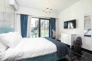 a bedroom with a white bed and a window at Rans Luxury Villas & Suites in Corfu with swimming pool in Gouvia