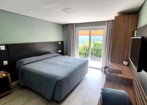 um quarto com uma cama e uma grande janela em Sky Palace Hotel em Gramado