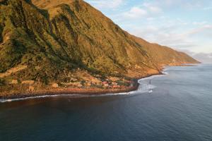 an aerial view of a mountain next to the ocean at Kuanza Nature Experience, Fajã do Belo in Fajã da Caldeira de Santo Cristo