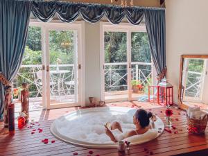 a woman laying in a bath tub in a room at Le Boutique Hotel Gramado - Exclusivo para Casais in Gramado