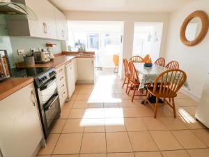 a kitchen and dining room with a table and chairs at Malltraeth Cottage in Bodorgan