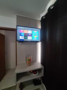 uma televisão de ecrã plano numa parede num quarto em Apt encantador: piscina, academia, tela proteção em Taguatinga