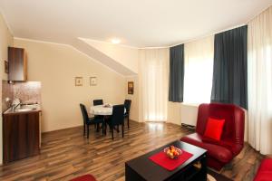 a living room with a red couch and a table at Apartments Izvor in Vrdnik