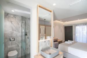 a bathroom with a bed and a shower and a sink at ALTHAEA LUXURY ROOMS in Skiathos