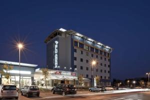 un edificio con coches estacionados en un estacionamiento por la noche en Blu Arena Hotel, en Montecchio