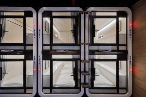a train with glass doors in a room at The O Pod Capsule Hotel in Tel Aviv