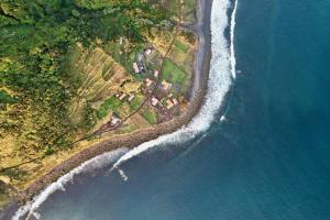 an aerial view of a house and the ocean at Kuanza Nature Experience, Fajã do Belo in Fajã da Caldeira de Santo Cristo