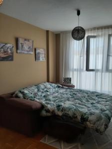 a bedroom with a bed in front of a window at La Playina in Cangas de Onís +5 photos