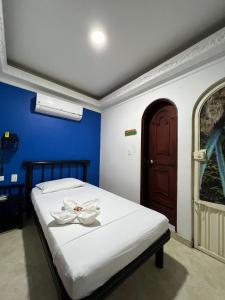 Un dormitorio con una cama con una flor. en Hotel Manoa en Cúcuta