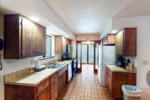 uma grande cozinha com armários de madeira e piso em azulejo em Forest Glen em Yosemite West