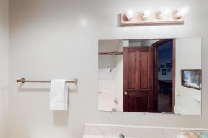 a bathroom mirror with a wooden door in it at Forest Glen in Yosemite West