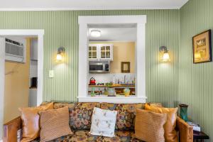 a couch in a living room with green walls at Charming 1923 Cottage at Erehwon Retreat in Tampa