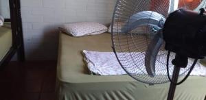 a room with two bunk beds with a fan at restaurante pousada gaucha bigode in Passo de Torres