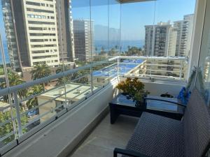 balcón con mesa y vistas a la ciudad en MARAVILLOSO Y NUEVO DEPTO 1 a 6 PERSONAS, en Viña del Mar