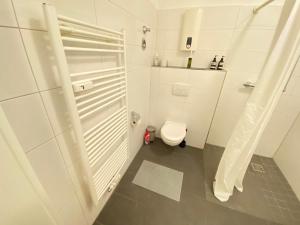 y baño blanco con aseo y ducha. en Apartment - 3 Einzelbetten - Stellplatz - Netflix en Goch
