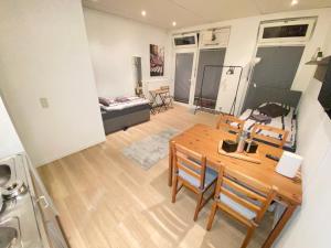 cocina y sala de estar con mesa de madera y sillas en Apartment - 3 Einzelbetten - Stellplatz - Netflix en Goch