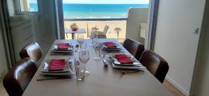 einen Esstisch mit Blick auf den Strand in der Unterkunft Belle Vue Mer Canet Plage accès piscine couverte et chauffée in Canet-en-Roussillon