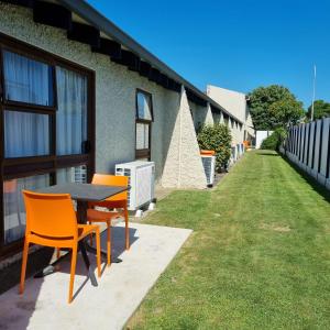 a table and chairs on the side of a house at Aztec Motel in Palmerston North