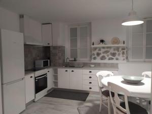 a kitchen with white cabinets and a table with a bowl on it at Kalymnos Gallery in Kalymnos