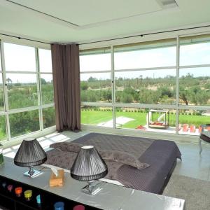 a bedroom with a large bed and large windows at Villa Loanaelle in Marrakech