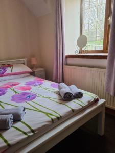 a bedroom with a bed with towels on it at Balnakiel Cottage, Galashiels in Torwoodlee