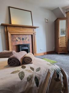a bedroom with a large bed with a fireplace at Balnakiel Cottage, Galashiels in Torwoodlee