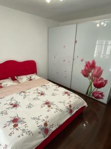 una camera da letto con un letto con un motivo floreale sopra di Apartament cozy a Drăgăşani