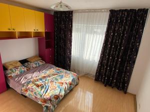 a bedroom with a bed and a window at Apartament cozy in Drăgăşani