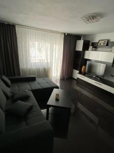 a living room with a couch and a tv at Apartament cozy in Drăgăşani