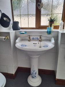 a white sink in a bathroom with a window at Balnakiel Cottage, Galashiels in Torwoodlee