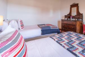 a bedroom with two beds and a dresser with a mirror at Aldeia da Cuada in Faja Grande