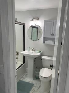 a bathroom with a sink and a toilet and a mirror at Villa Venezia in Fort Lauderdale