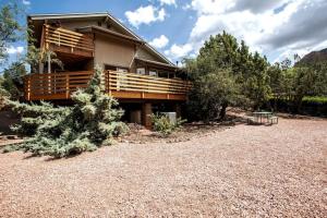 a house with a deck and a bench in front of it at Spacious & Beautiful with Double Decks in Chapel Area in Sedona