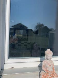 a statue of a child sitting in front of a window at Au bord de l’eau in Orpund