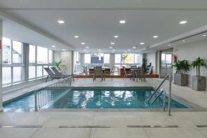 an indoor swimming pool in a building with a dining area at Laghetto Stilo Vita in Gramado