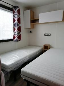 two beds in a room with a window and a window at Bora Bora 6/8 personnes in Litteau